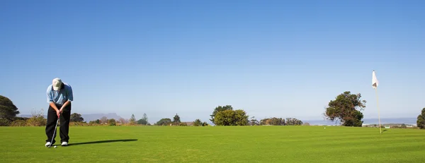 En golfare att spela golf på en grön — Stockfoto