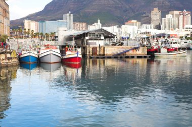 Cape town waterfront Limanı deniz ve şehir manzarası arka planda yansıtan üç tekne ile.