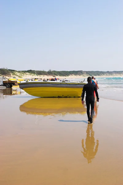 A diver walking towards a rubber boat. — Stock Photo, Image