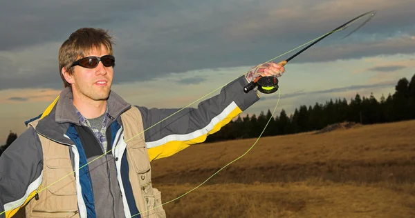 Un pescador de mosca lanzando una línea en Dullstroom, Sudáfrica — Foto de Stock