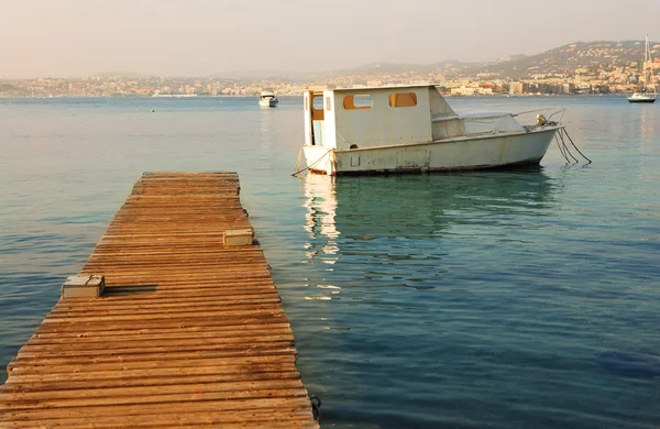 Velho barco de pesca ao lado do cais de Ile Sante-Marguerite Cannes no fundo, França — Fotografia de Stock