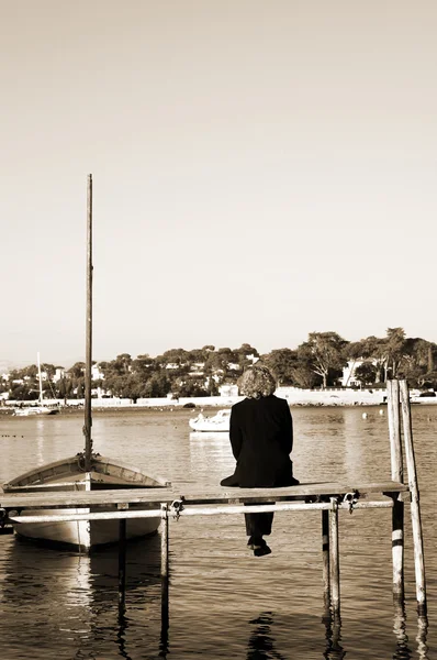 Een persoon zit op een pier in antibes, Frankrijk — Stockfoto