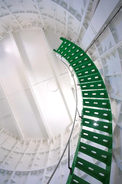 Зеленая металлическая винтовая лестница внутри белого маяка — стоковое фото