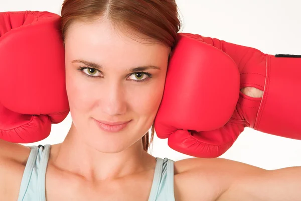 Uma mulher em roupas de ginástica, vestindo luvas de boxe vermelho . — Fotografia de Stock