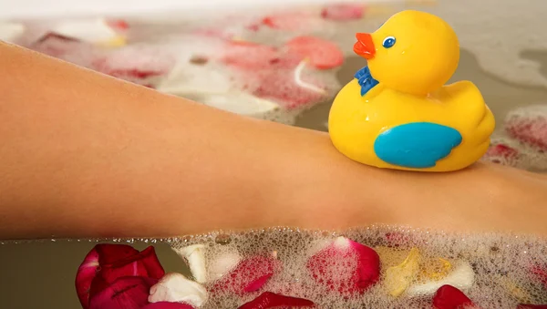 El pie de una mujer con un pato de juguete de plástico en él —  Fotos de Stock