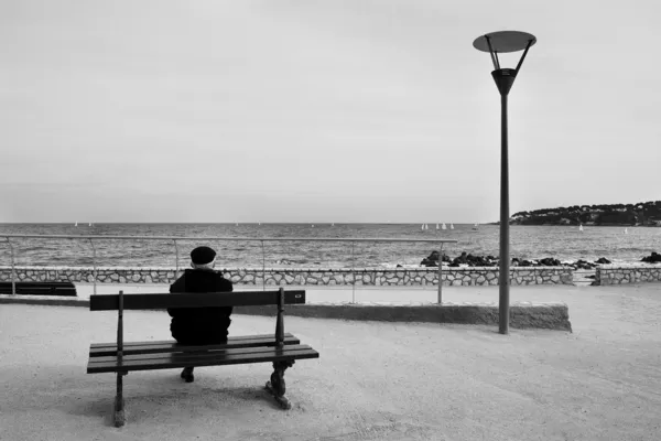 Man on Bench, next to the sea — Stock Photo, Image