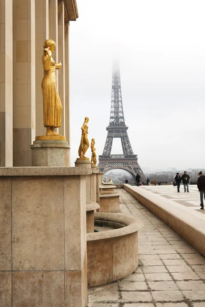 Uma estátua de ouro em primeiro plano com a Torre Eiffel em Paris — Fotografia de Stock