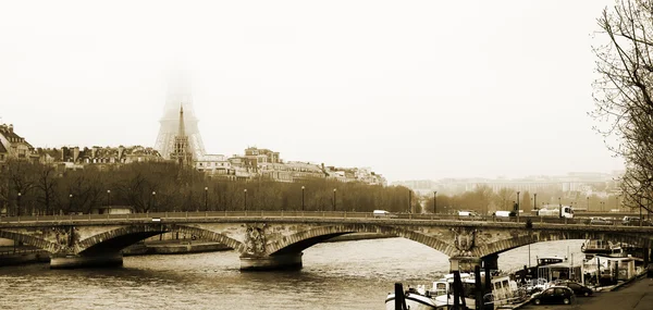 Ponte em Paris, França. Torre Eiffel apenas visível no nevoeiro . — Fotografia de Stock