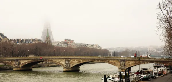 Bridge in Paris, France. Eiffel Tower just visible in the fog. — Stock Photo, Image