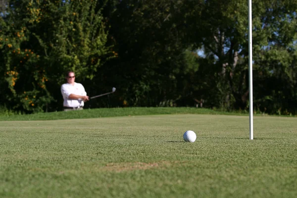 Golfspelare bredvid gröna — Stockfoto