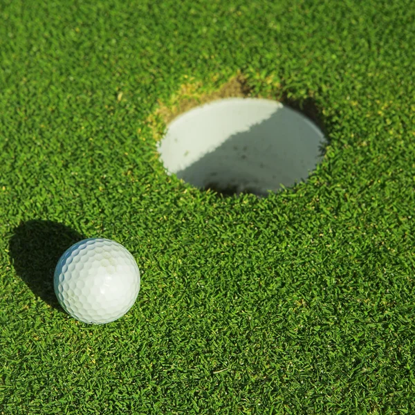 Uma bola de golfe em um verde — Fotografia de Stock