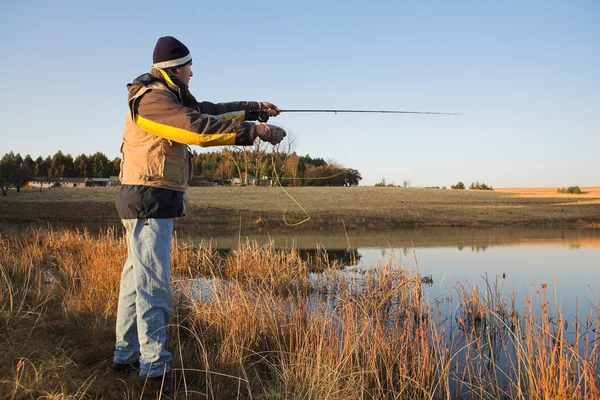 Un pescador de mosca lanzando una línea en Dullstroom, Sudáfrica —  Fotos de Stock