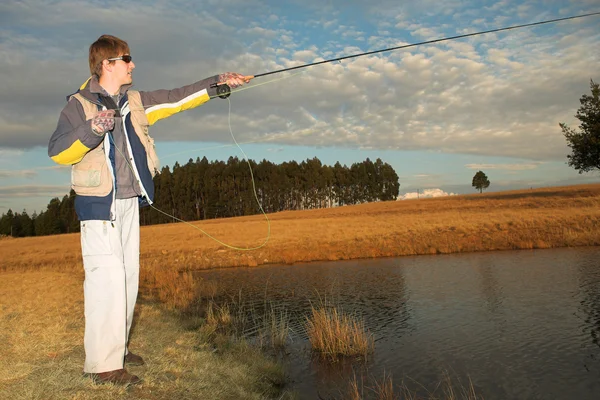 Een vliegvisser gieten van een lijn in dullstroom, Zuid-Afrika — Stockfoto