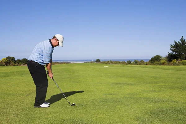 Um golfista jogando golfe ao ar livre na paisagem natural — Fotografia de Stock