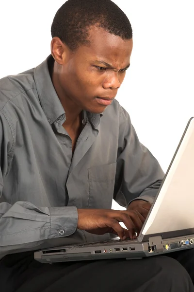 Επιχειρηματίας με γκρι πουκάμισο, συνεδρίαση, να εργάζονται σε ένα φορητό υπολογιστή — Φωτογραφία Αρχείου