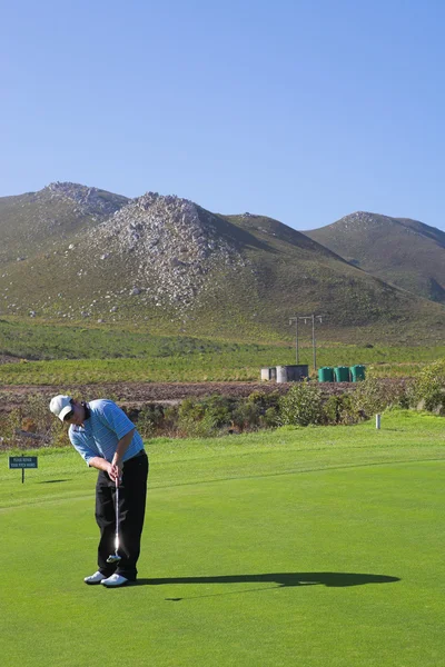 En golfare att spela golf på en grön — Stockfoto