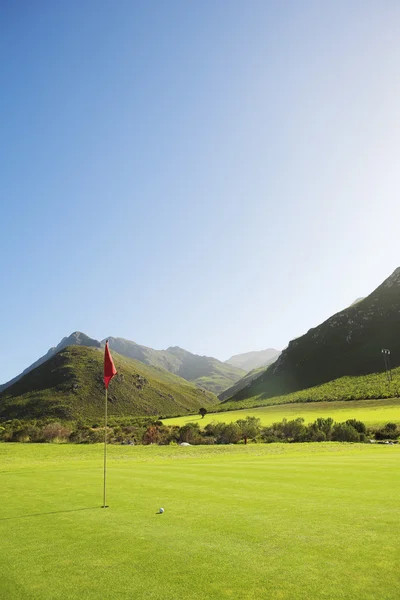 Golfplatz mit roter Fahne. — Stockfoto