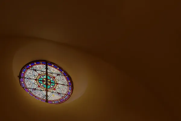 Stained glass window close to the roof inside a chapel — Stock Photo, Image