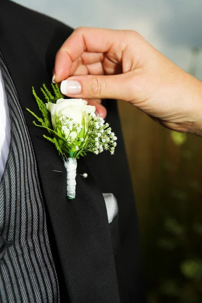 Närbild av brud-tillbehör. hand av bruden fastställa en corsage. — Stockfoto