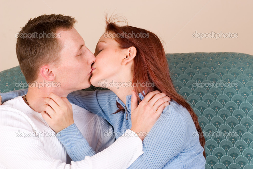 Woman and boyfriend kissing on couch