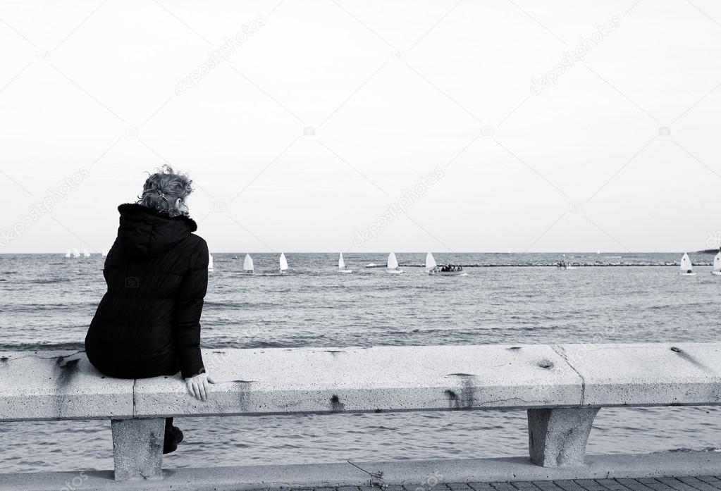 A person sitting on a pier in Antibes, France