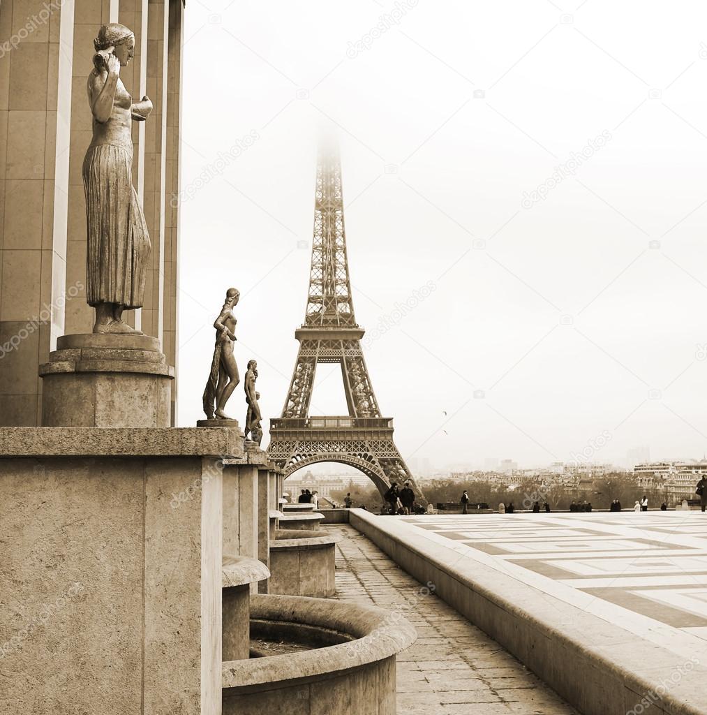 A golden statue in the foreground with the Eiffel Tower in Paris, France