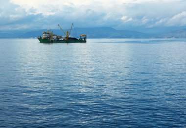 Harbor'a bırakarak tek küçük bir balıkçı trol bulutlu bir kış gününde balığa mavi Ege Denizi.