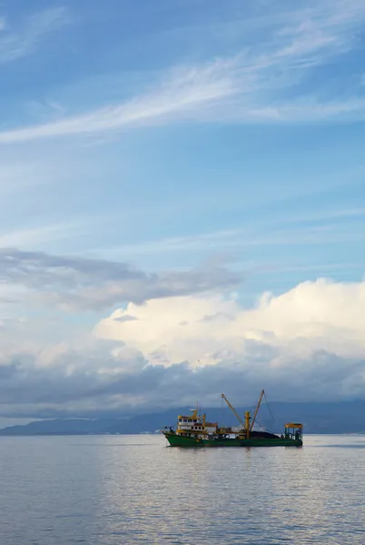 Solo pequeño arrastrero de pesca que sale del puerto en el mar Egeo azul para ir a pescar en un día nublado de invierno . — Foto de Stock