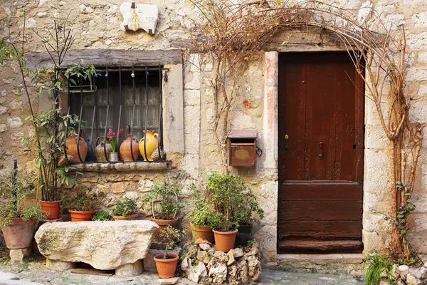 Giardino di strada con nome di strada e piante in vaso di fronte a finestre e porte nel pittoresco paesino collinare francese di Saint-Paul de Vence, nel sud della Francia, patrimonio dell'umanità — Foto Stock