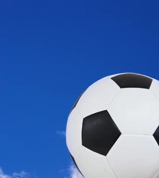夏の青い空を背景黒と白のサッカー ボール. — ストック写真