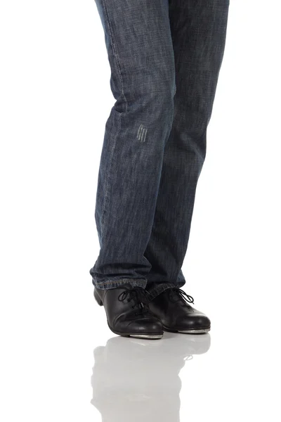 Single male tap dancer wearing jeans showing various steps in studio with white background and reflective floor. — Stock Photo, Image