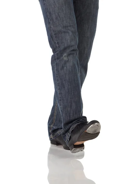 Single male tap dancer wearing jeans showing various steps in studio with white background and reflective floor. — Stock Photo, Image