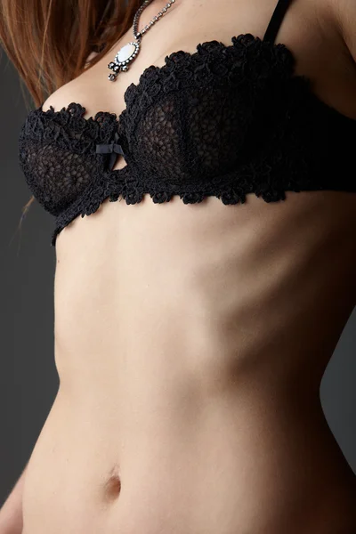 Jovem mulher caucasiana adulta vestindo lingerie renda preta em um fundo cinza neutro . — Fotografia de Stock