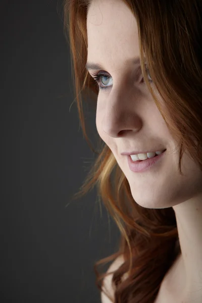 Young caucasian adult redhead woman with green eyes and very fair skin in black lingerie on a neutral grey background — Stock Photo, Image