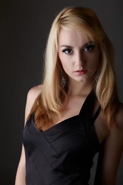 Mladé dospělé Kavkazský žena s blond vlasy a výrazné šperky na neutrálním šedém pozadí černé spodní prádlo a velké hnědé oči — Stock fotografie