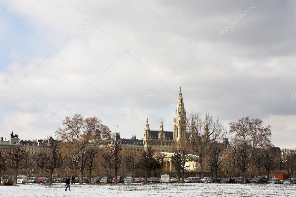 The Town Hall (Wien Rathaus) buildings in Vienna, Austria across a snow covered park.