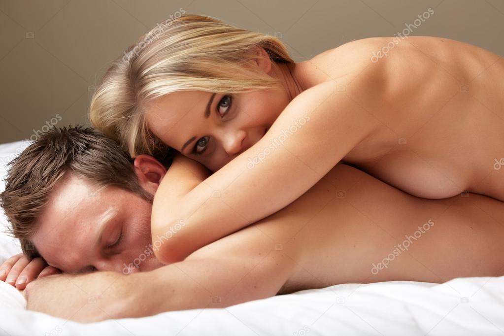 Young and fit caucasian adult couple lying on naked on a bed.