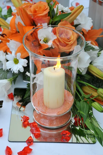 Vela com arranjo de flores com rosas rosa e laranja Fotos De Bancos De Imagens