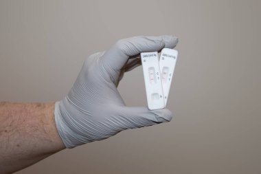 Eldivenli el, hızlı COVID-19 antijen test kiti pozitif sonuç veriyor. Yanal akış testi.