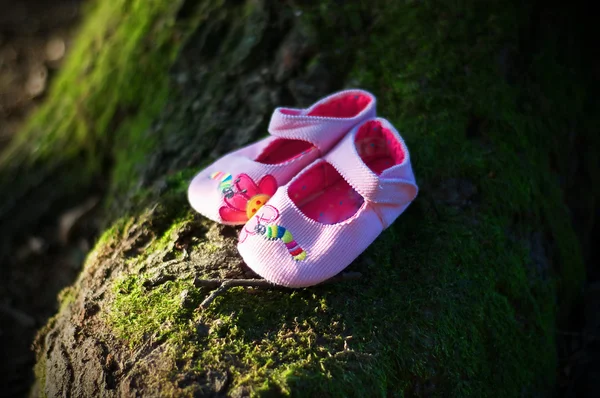 Pink baby schoenen in een groene natuurrijke omgeving — Stockfoto