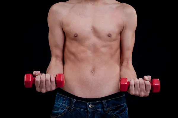 Fit young man exercising with red dumbbell on black background — Stock Photo, Image