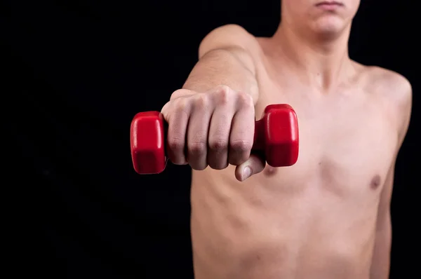 Jovem treina músculos — Fotografia de Stock