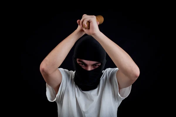 Masked man aims and attack with bat — Stock Photo, Image