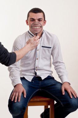 genç bir adamın ağzında bir büyüteç ile oynarken komik resim