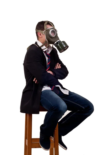 Muž s plynovou masku, sedí na židli — Stock fotografie