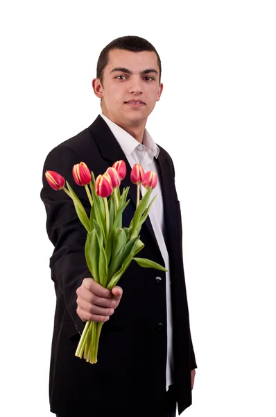 Ung man erbjuder tulpan blommor — Stockfoto