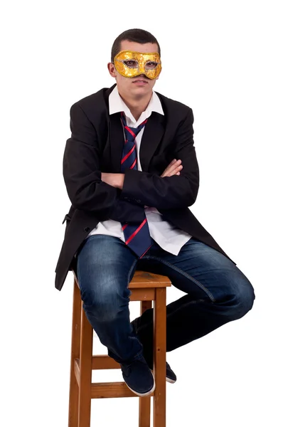Młody mężczyzna siedzi na krześle i noszenie maski weneckie — Zdjęcie stockowe