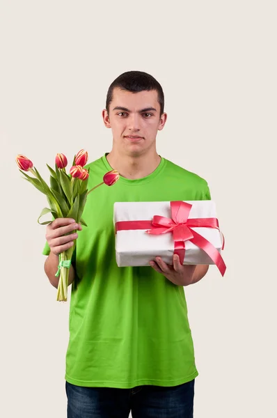 Junger Mann mit einem Strauß Tulpen und Geschenkbox — Stockfoto