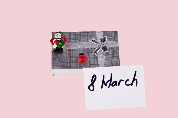 Geschenkschachtel mit Marienkäfern und Postkarte auf rosa Hintergrund — Stockfoto