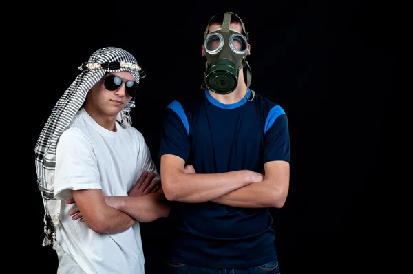 Jovem árabe com óculos de sol e um jovem com máscara de gás — Fotografia de Stock